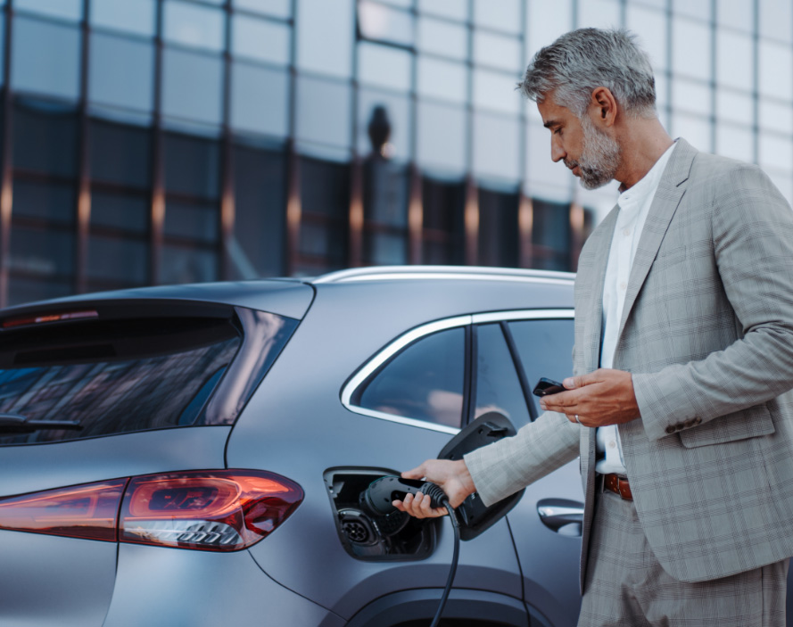 Well-dressed employee plugging into his workplace EV charger